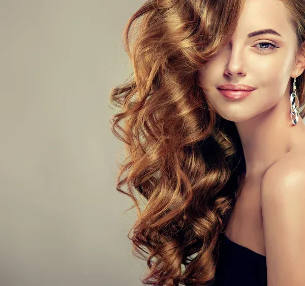 Woman with glossy, voluminous caramel brown curls